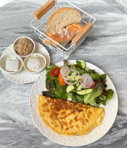 a plate of food with a salad and a plate of bread at H7 TLV in Tel Aviv