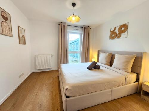 a bedroom with a large white bed and a window at Le Silvestre in Bouliac