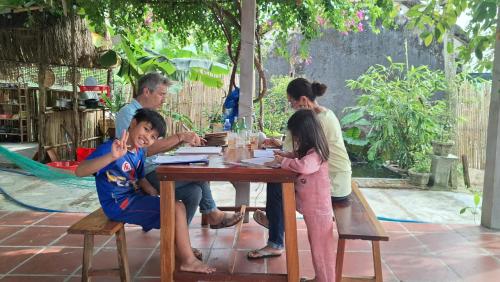 een groep mensen die aan een tafel zitten bij Homestay Dat Phu in Tuy Hoa