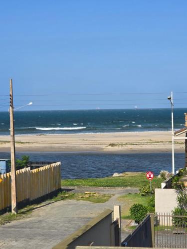 een uitzicht op een strand met een stopbord bij Ótimo apartamento com ampla sacada e vista pro mar in São Francisco do Sul