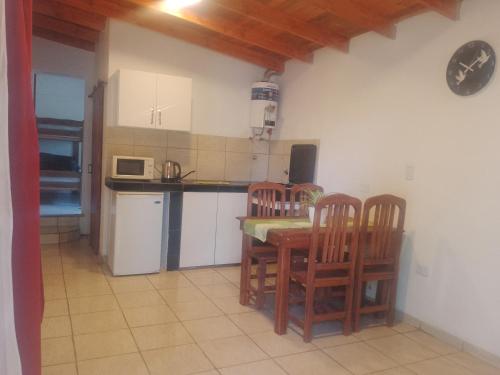 eine Küche mit einem Tisch, 2 Stühlen und einer Theke in der Unterkunft Depto Calamuchita Rumipal in Villa Rumipal