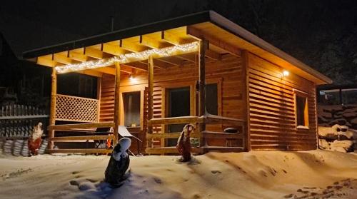 a log cabin with people standing outside in the snow at DingDing in Unteraichwald