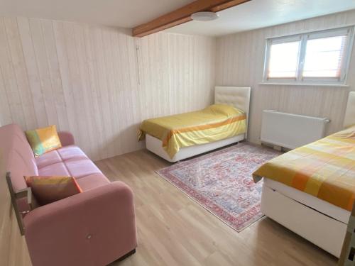 una piccola camera con due letti e un divano di Cozy ground floor apartment a Xonrupt-Longemer