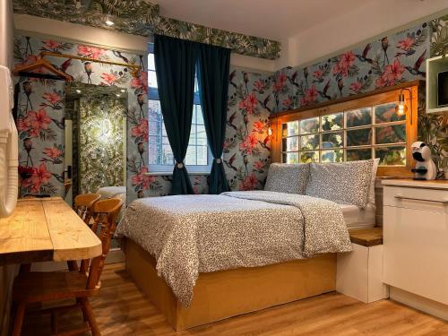 a bedroom with a bed and a table and a window at RB Portobello in London