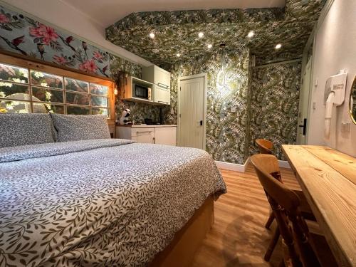 a bedroom with a bed and a table and a kitchen at RB Portobello in London