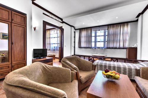 een woonkamer met banken en een tafel met een fruitschaal bij Спа Хотел Орфей in Devin