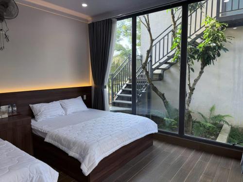 Tân PhúCoco Retreat的一间卧室，里面有一张床和一扇大窗户。