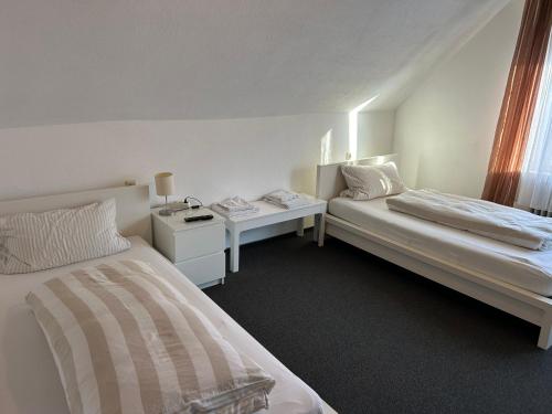una camera d'albergo con due letti e un comodino di Central Apartment Rödermark 3SZ a Rödermark