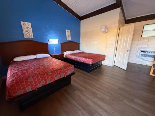 een kamer met twee bedden en een blauwe muur bij Royal inn in Quincy