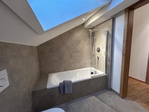 a bathroom with a bath tub with a skylight at Landhaus Sonnenwang in Pfronten