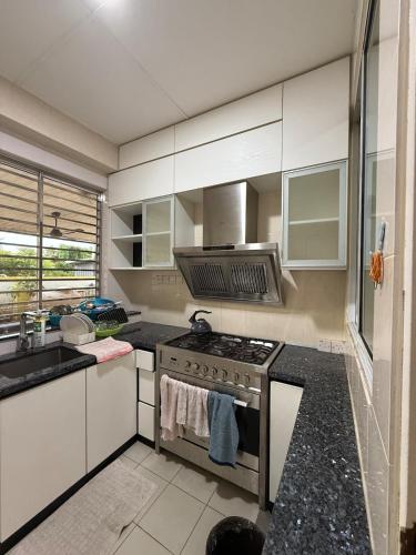 a kitchen with a stove and a sink at The Luxe Stay in Kuching