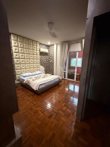 a bedroom with a bed and a wooden floor at The Luxe Stay in Kuching