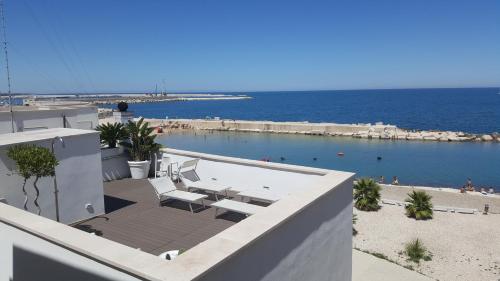 a view of a swimming pool and the ocean at MoMa Molfetta Mare in Molfetta