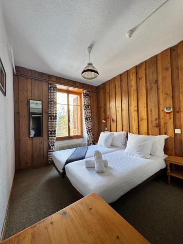 una camera con due letti in una stanza con pareti in legno di Grand Hôtel & Kurhaus ad Arolla