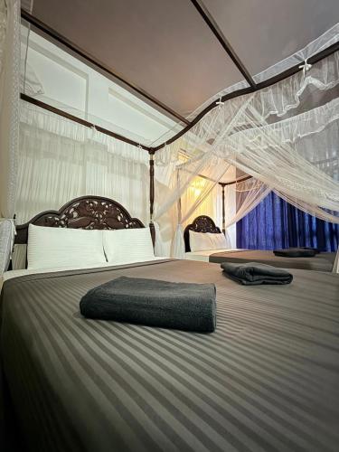 a large bed with a net on top of it at Poppies Mirissa in Mirissa