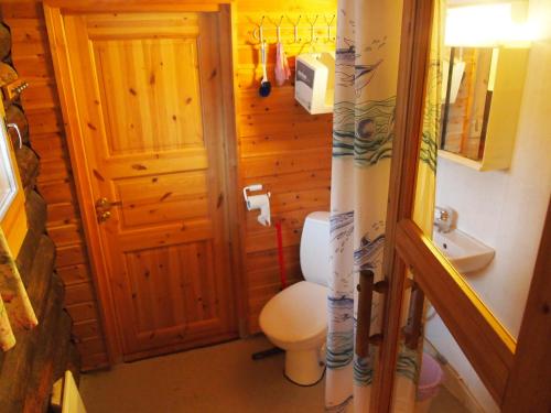 a small bathroom with a toilet and a sink at Ahkun Tupa in Lemmenjoki