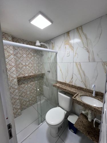 a bathroom with a toilet and a sink and a shower at Flats Brisa Antunes in Maragogi