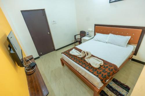 een slaapkamer met een bed met twee schoenen erop bij Aryas Residency- Near Isha Foundation Coimbatore & Karunya University in Alāndurai