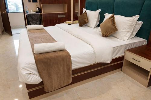 a bedroom with a large bed with white sheets and pillows at Hotel Gulmohar Tree in Jāmb