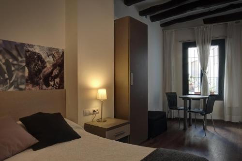 um quarto com uma cama, uma secretária e uma mesa em Hostal Agrobotiga 7 de Ribera em Móra d'Ebre