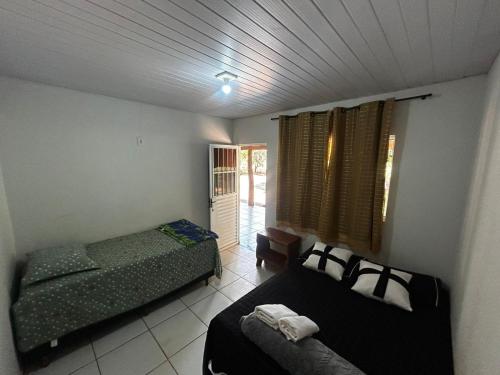 诺布里斯Pousada São Martins的一间小房间，里面有两张床和一个窗户。