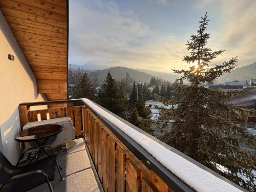 een balkon met uitzicht op een met sneeuw bedekte boom bij Willa Górska Pasja in Szczyrk