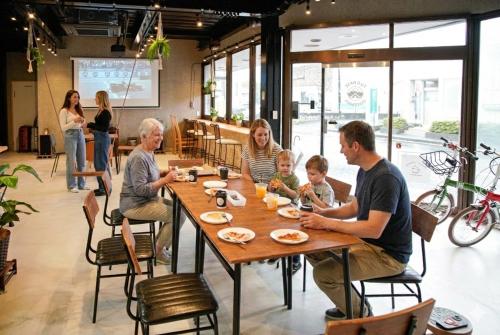 a family sitting at a table in a restaurant at 富士Base御殿場 Station-Side Hideout in Gotemba