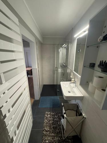 ein weißes Badezimmer mit Waschbecken und Spiegel in der Unterkunft Nostalgie 2 in Bad Harzburg