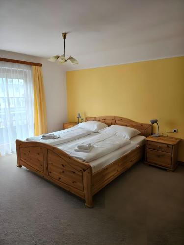 a bedroom with a large wooden bed and a window at Ferienhaus Sinning in Leogang