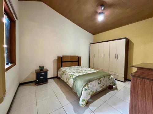 a bedroom with a bed and a cabinet in it at Casa do Cerrado in Santana do Riacho