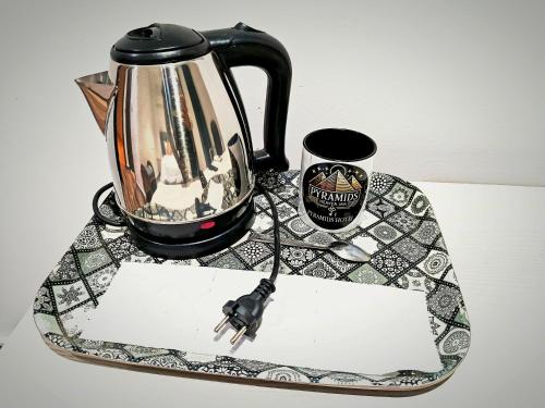 een tafel met een waterkoker en een sleutel bij Pyrs Giza Heaven in Caïro