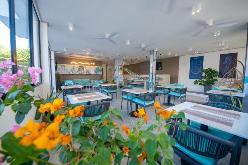 een restaurant met blauwe tafels en stoelen en bloemen bij Sunwave Dhigurah in Dhigurah