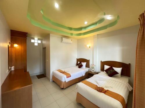 een hotelkamer met twee bedden en een groen plafond bij Sunsea Resort in Baan Khai