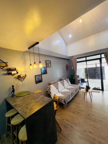 a living room with a couch and a table at Homey Hideout- Athena and Noah Units in Magalang