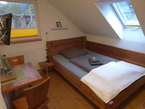a bedroom with a bed and a table and a window at Haus am Stausee in Altenbeuthen