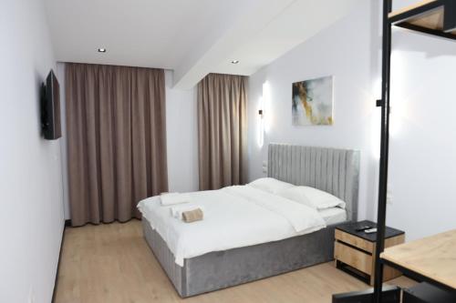 een hotelkamer met een bed en een televisie bij Kremelo Hotel in Berat