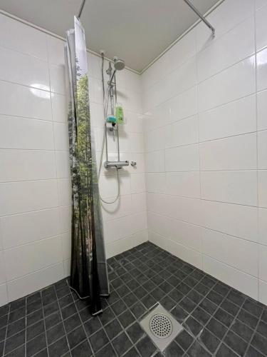 a shower with a shower curtain in a bathroom at Modern studio apartment with free parking in Kuopio