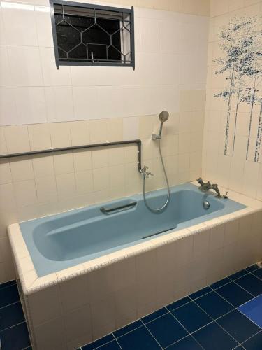 a bath tub with a shower in a bathroom at 786 Bali Top Homestay in Sungai Petani