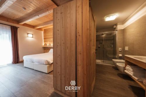 a bedroom with a bed and a shower and a bathroom at Hotel Derby in Bormio