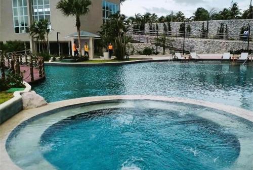 einem großen Pool mit blauem Wasser vor einem Gebäude in der Unterkunft Casa de Praia Atalaia in Salinópolis