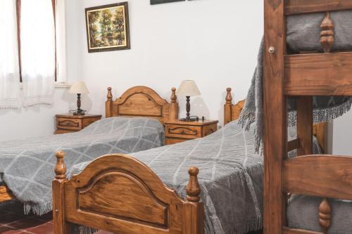 een slaapkamer met 2 houten bedden en 2 lampen bij Casa Ganesha Chapadmalal in Chapadmalal