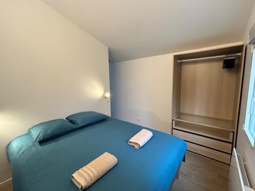 a bedroom with a blue bed with two towels on it at Solar Dream - close to Disney in Lagny