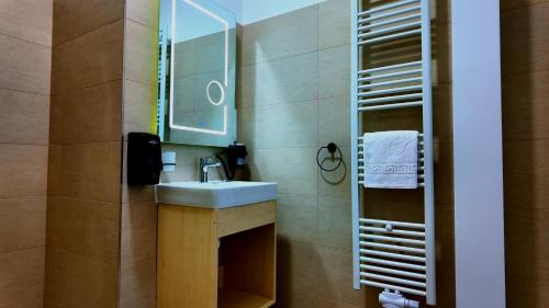 een badkamer met een wastafel en een spiegel bij Niko Hotel am Hannover Hbf in Hannover