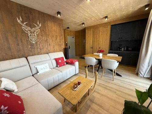 een woonkamer met een bank en een tafel bij Apartmán Forest, Tatranská Štrba in Tatranska Strba