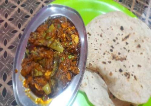 een lepel eten op een bord met een tortilla bij MG stay in Jorhat