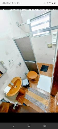 a bathroom with a toilet and a sink at Hostelval Cantinho praia do sossego in Praia Grande