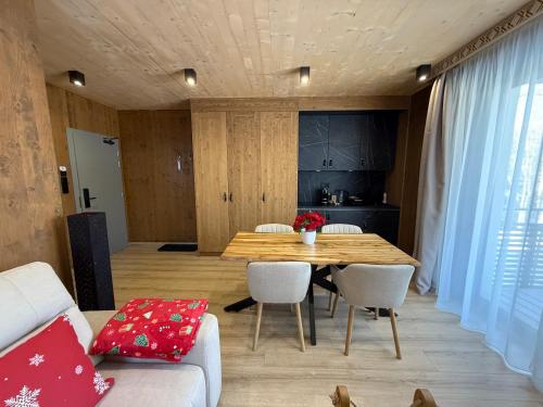 een eetkamer met een houten tafel en witte stoelen bij Apartmán Forest, Tatranská Štrba in Tatranska Strba