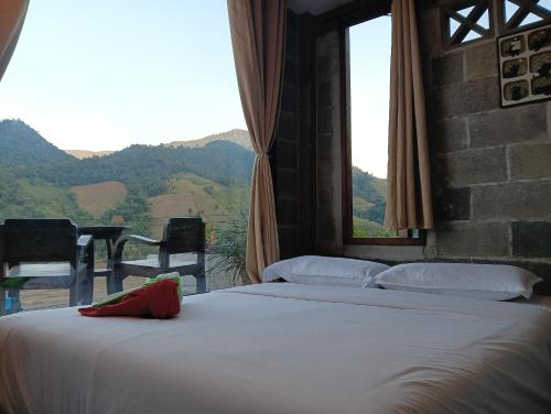 een slaapkamer met 2 bedden en een raam met uitzicht op de bergen bij บ้านนอร์ดบล็อกเวนิสบ้านเวร in Ban Khun Nam Nan