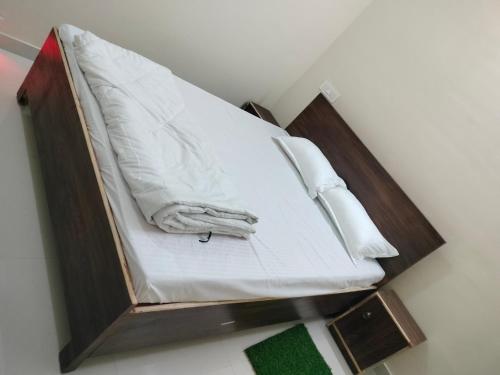 a bed with white sheets and pillows on it at Hotel Krishn Residency in Garwa Road