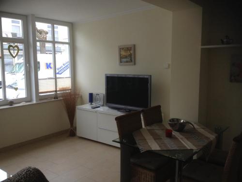 a living room with a flat screen tv and a table at Fewo31, exklusive Apartments, 2 Minuten vom Strand und Alten Strom in Warnemünde